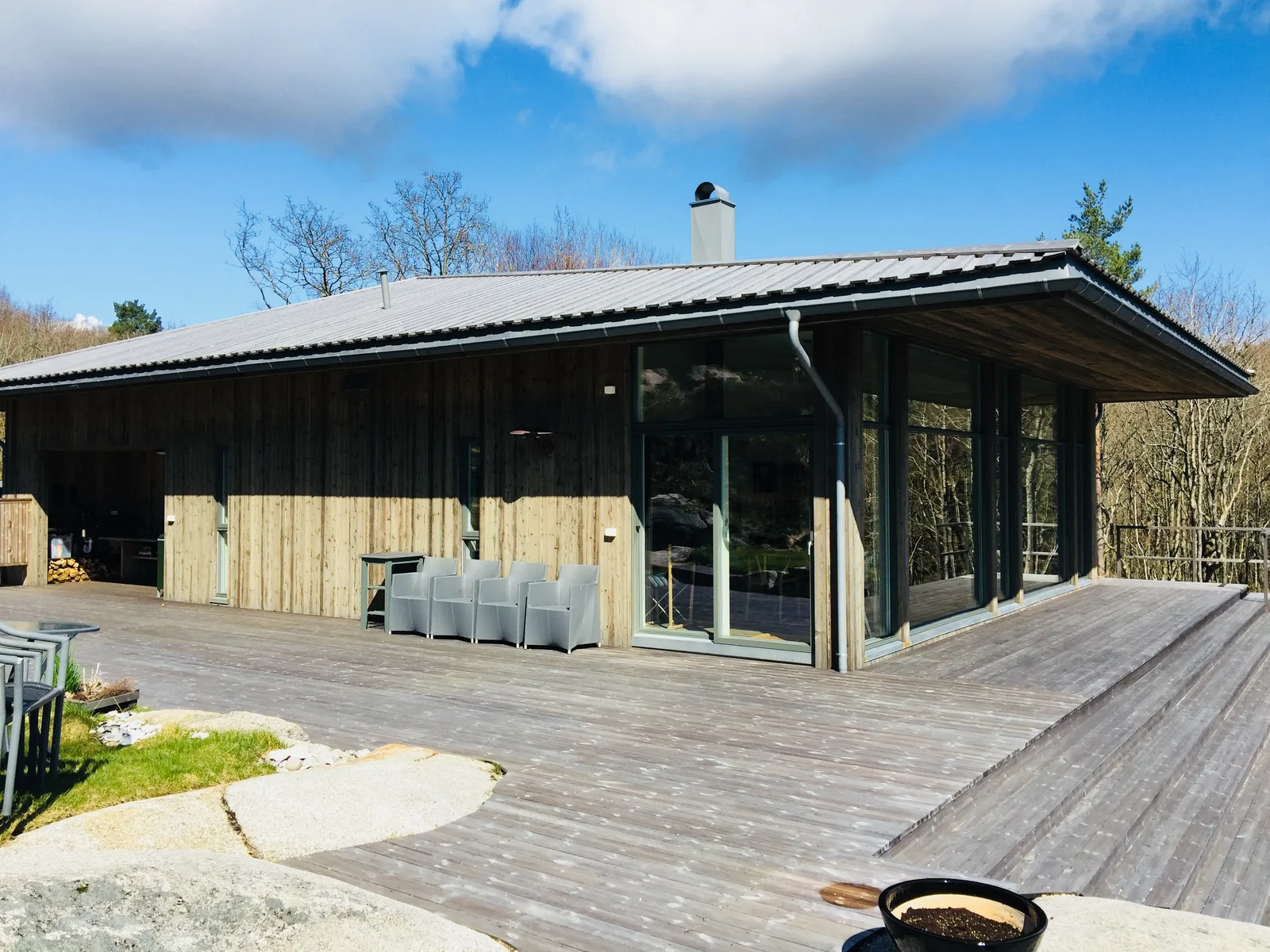 Trehytte med store glassflater og terrasse.